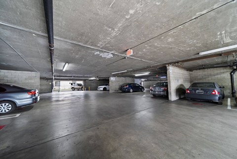 A parking garage with several cars parked in it.