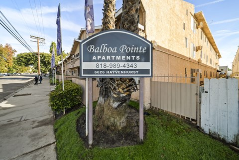 A sign for Balboa Pointe Apartments is displayed in front of a building.