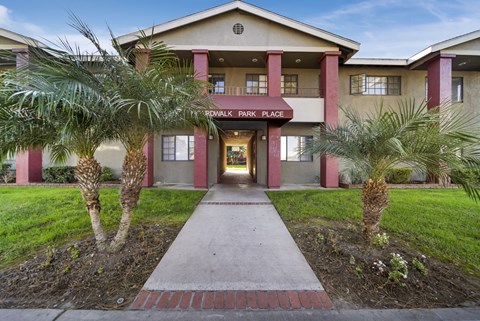 The front of a building with a red brick pathway leading to the entrance.