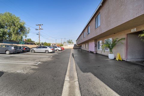 A parking lot with cars parked and a building on the right side.