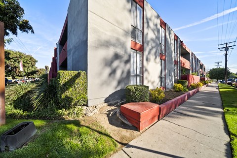 A long building with red trim and a red planter box on the side.