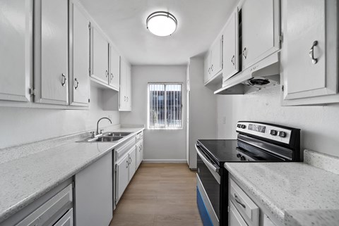 A kitchen with white cabinets and a black stove top oven.