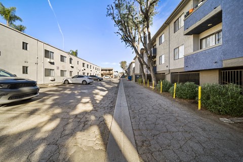 A street view of a residential area with cars parked on the side of the road.