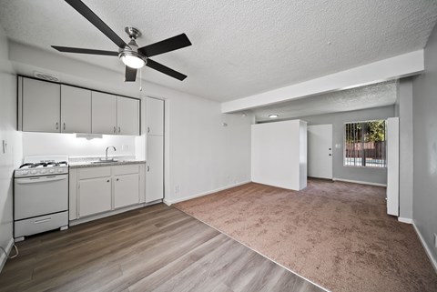 A spacious living room with a kitchen area in the background.