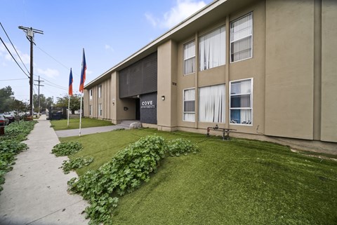 A building with the word "COVE" on the side is surrounded by greenery.
