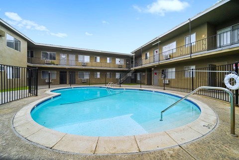 A swimming pool in a courtyard surrounded by apartment buildings.