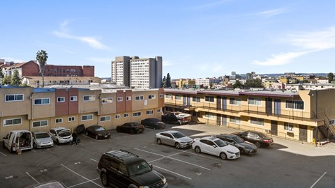 A parking lot with cars and apartment buildings in the background.