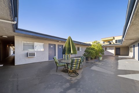 A patio with a table and chairs under a green umbrella.