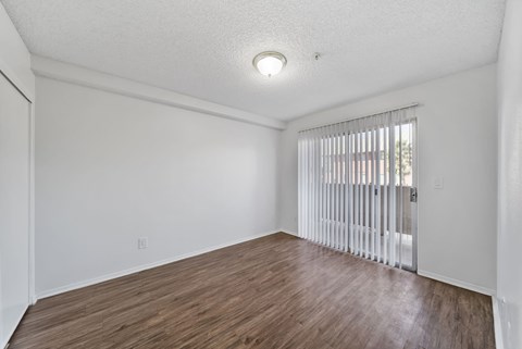 A room with wooden flooring and white walls.