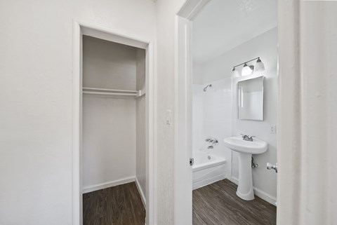 A white bathroom with a sink and a mirror.