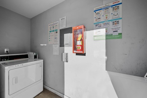 A white washing machine sits in a laundry room with a white dryer.