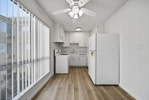 A kitchen with white appliances and cabinets is shown.