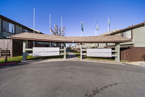 A building with a covered walkway and flags on top.