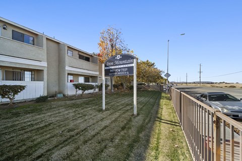 A sign for Iron Mountain Apartments stands in front of a building.