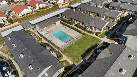 A bird's eye view of a residential area with houses and a swimming pool.