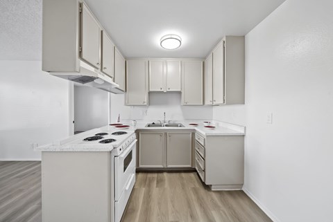 A kitchen with white appliances and cabinets.