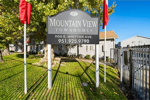 A sign for Mountain View Townhomes stands in front of a building.