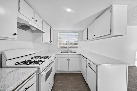 A white kitchen with a stove and cabinets.