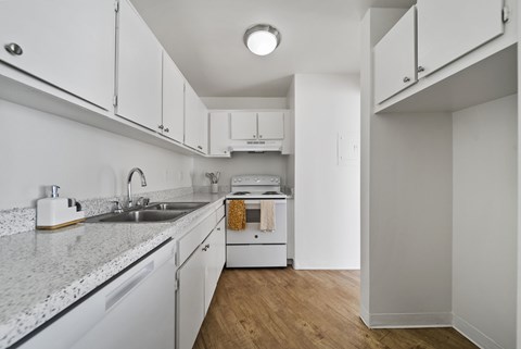 A kitchen with white cabinets and a granite countertop.