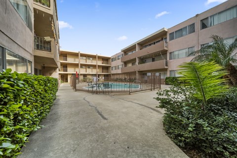 A courtyard with a pool surrounded by buildings and greenery.