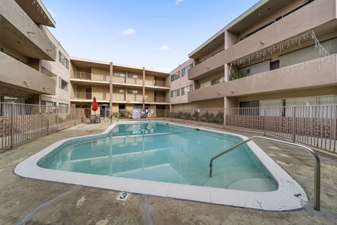 A small pool in a courtyard surrounded by buildings.