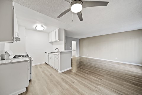 A modern kitchen with a white cabinet and a wooden floor.