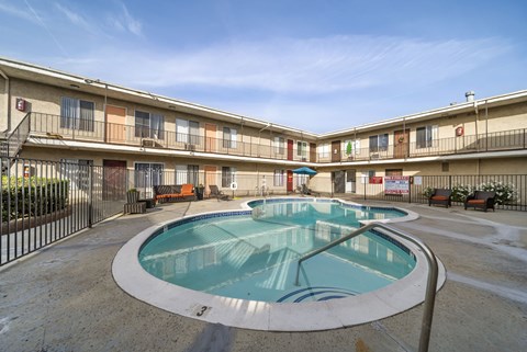 A large outdoor pool in a courtyard surrounded by apartment buildings.