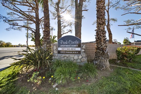 A sign for Park Circle Apartment Homes stands in front of a building.