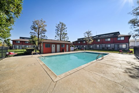 A swimming pool in front of a red building.