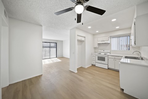 A white kitchen with a fan on the ceiling.