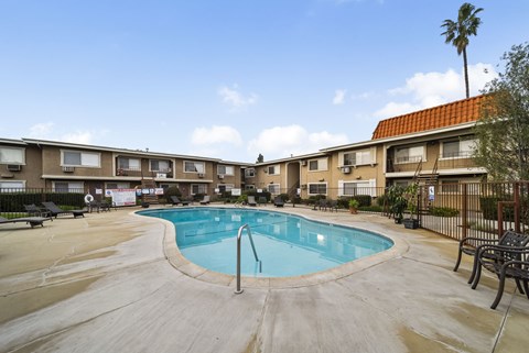 A swimming pool in a courtyard surrounded by apartment buildings.