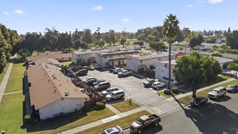 A parking lot with cars and a building in the background.