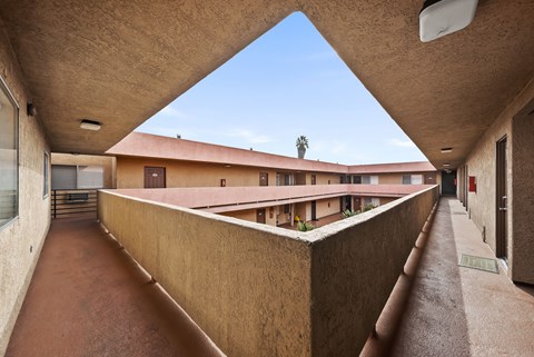 A long hallway with a roof that is sloped in the middle.