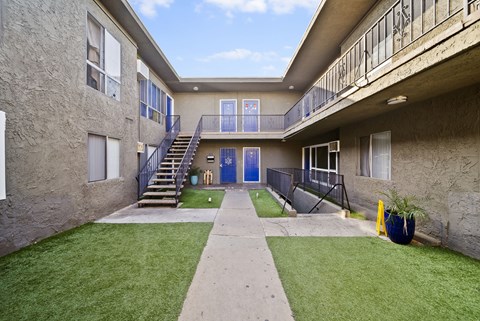 A courtyard with a staircase and a blue door.