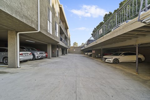 A parking garage with cars parked on both sides.
