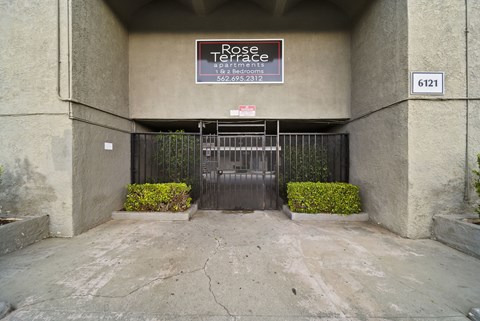 A sign for Rose Terrace is on the wall above a gate.