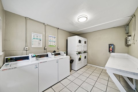 A clean, white-walled room with a white table and a white oven.
