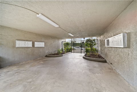 A concrete room with a planter and two white boards on the wall.