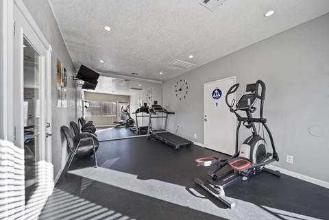 A modern home gym with a treadmill, elliptical trainer, and other exercise equipment.