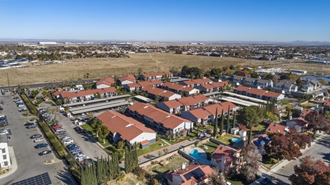 A bird's eye view of a residential area with houses and parked cars.