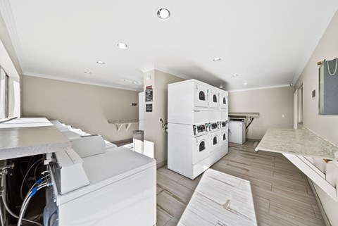 A kitchen with white appliances and wooden flooring.