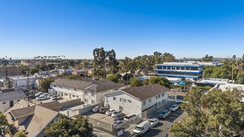 A clear blue sky over a residential area with houses and parked cars.