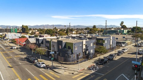 A street view of a residential area with houses and cars.