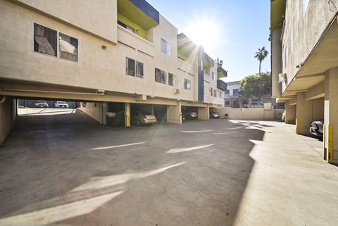 A sunny day at a parking lot with cars and buildings.