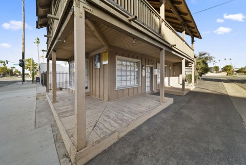 A wooden building with a porch and a covered walkway.