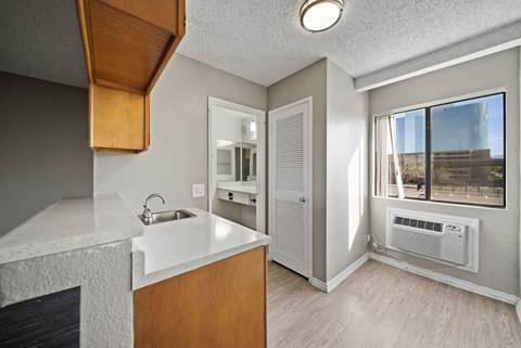 A kitchen with a white counter top and wooden cabinets.