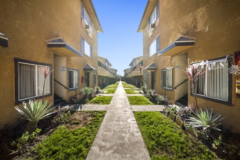 A row of houses with a concrete walkway between them.