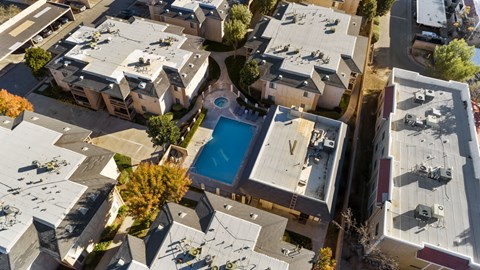 A bird's eye view of a residential area with a swimming pool.
