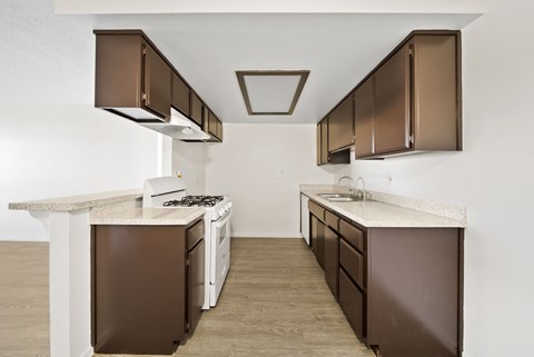 A kitchen with brown cabinets and a white counter.