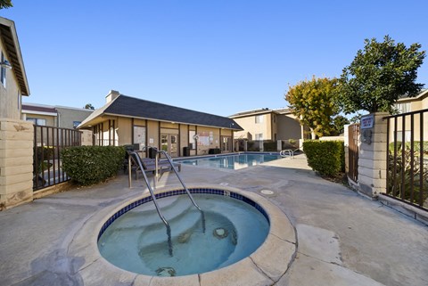 A hot tub sits in the middle of a patio.